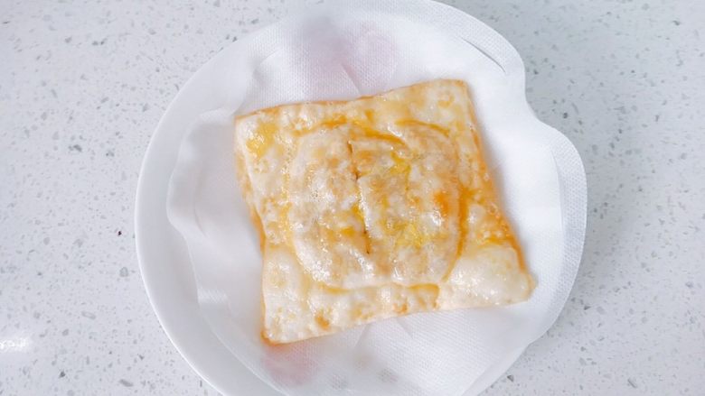 嫩脆香蕉派,二面差不多程度的金黄,就夹起来吧!这个时候香蕉派的香味早已散发出来了。盘子上铺层油纸,吸下油。