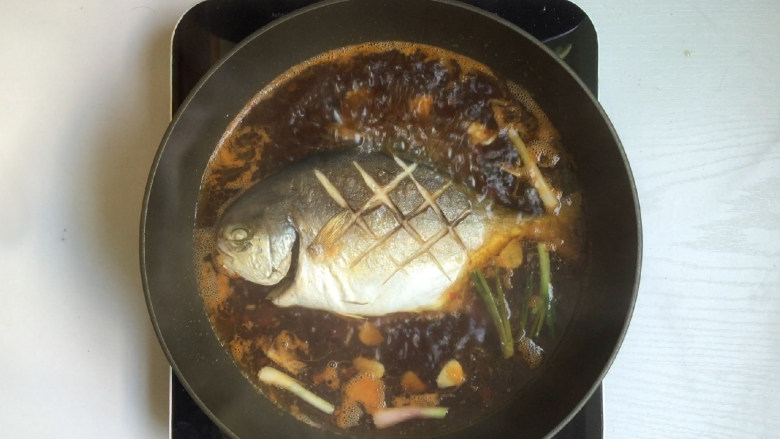 红烧鲳鱼,9.烧开后放入鲳鱼,盖上盖子,转小火慢炖