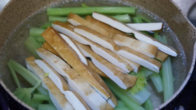 完美便当方程式「25」,锅中烧开水,先下入西芹焯烫30秒,然后加入豆干焯烫至锅中水再次开启即可