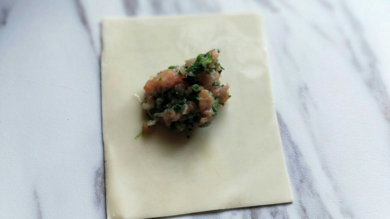 【营养早餐】荠菜大馄饨,取一张馄饨皮,放入馅料。