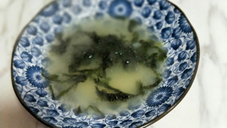 【营养早餐】荠菜大馄饨,将熬好的骨头汤放入器具中,加入<a style='color:red;display:inline-block;' href='/shicai/ 273'>紫菜</a>。