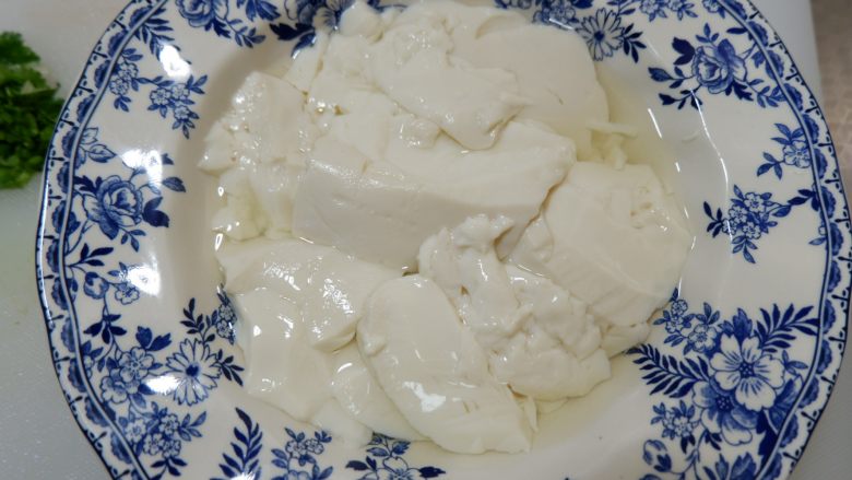 完美便当方程式「15」,用一个大一点的平勺,挖出豆腐花。我买的是做好的豆腐脑,<a style='color:red;display:inline-block;' href='/shicai/ 9656'>内脂豆腐</a>也可以的。放入微波炉2-3分钟,蒸好的豆腐脑取出,小心的倒出一部分蒸出的水。