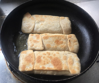 褡裢火烧,待一面煎微黄翻面,刷一层油
