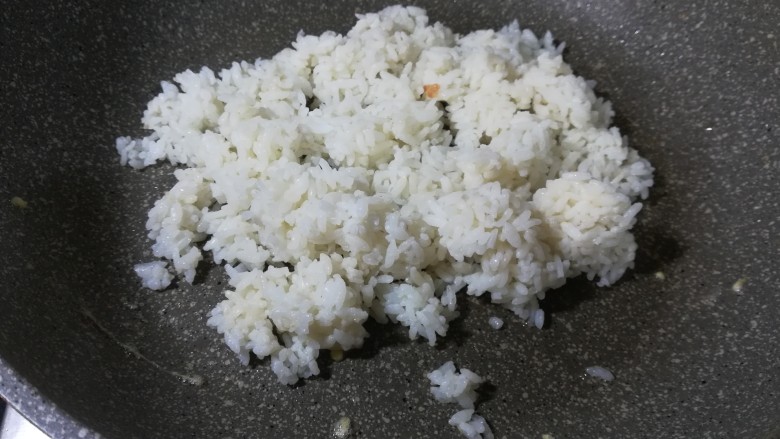 美味蛋炒饭,锅里放少许油,倒入米饭。