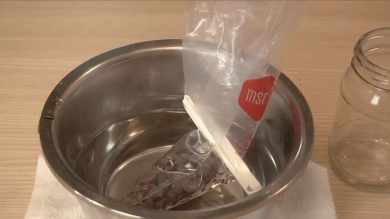 可可戚风巧克力围边奶油蛋糕,巧克力切碎(用可可含量60%以上的黑巧克力,如果可可含量过低,不经过调温巧克力很容易融化),放入耐高温的裱花袋,放入热水中融化(热水温度55度左右,手可以触碰的温度,温度过高会使巧克力油水分离,变得粗糙),