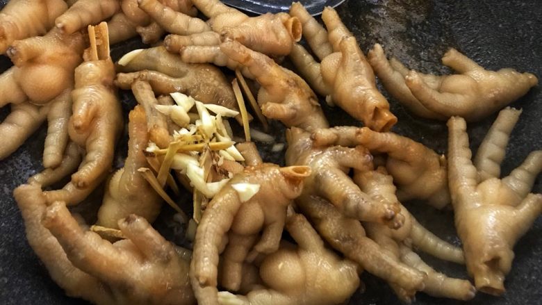 红焖啤酒鸡爪(香辣风味),加入姜丝蒜蓉翻炒。