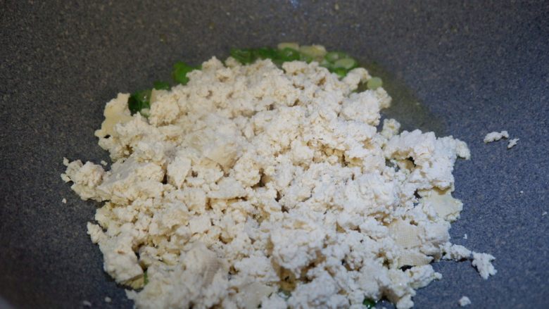 儿童食谱—鸡刨豆腐,再倒入豆腐碎,快速翻炒约30秒。