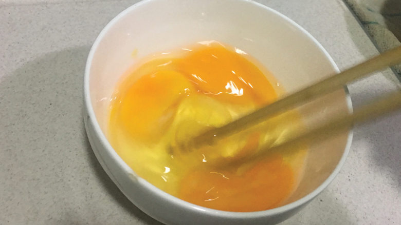 黄梨炒饭,容器内打入鸡蛋,加入适量的盐,用筷子搅匀