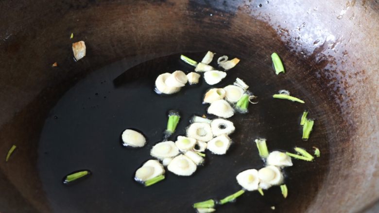 土豆豆角焖面,锅内放适量的色拉油,放入大蒜炒香;