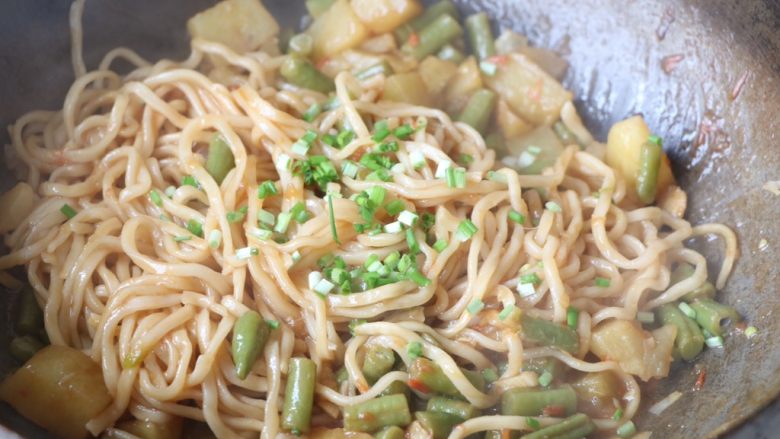 土豆豆角焖面,直到大部分水分炒干,食材熟透,出锅之前加入葱花即可;