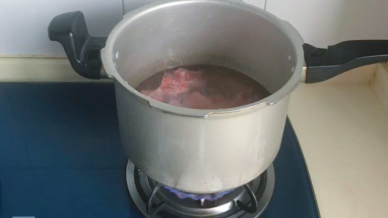高压锅快速焖猪骨,倒入高压锅中,加入适量的清水,大火煮开后看到有浮沫出现即可,水里冲洗干净浮沫