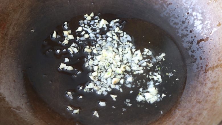 土豆豆角焖饭,锅内放适量的色拉油,放入大蒜末炒香;