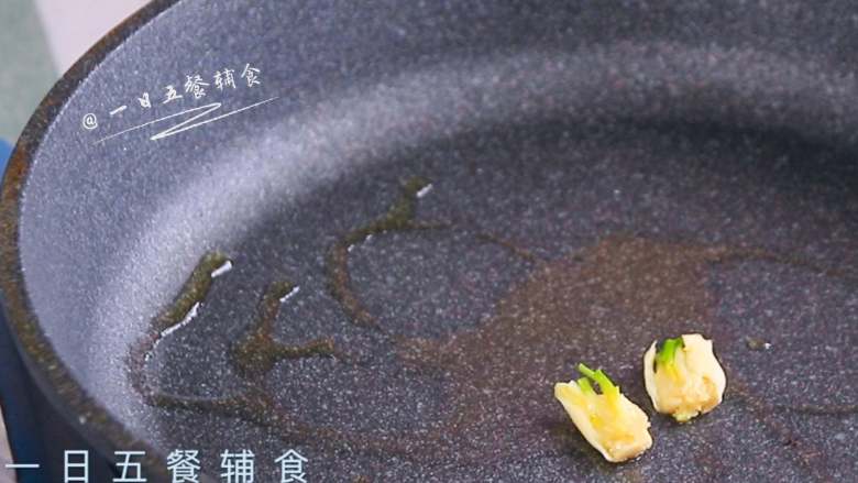 猪肝茼蒿炒鸡蛋,热锅倒橄榄油,蒜放入扁香,闻到香味,蒜取出来。