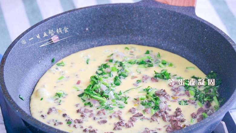 猪肝茼蒿炒鸡蛋,蛋奶液加入,等底部蛋液凝固。