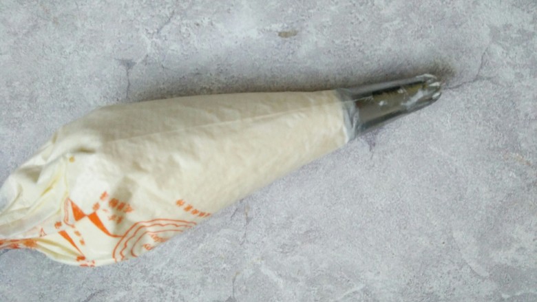 芒果蛋糕盒子,然后取一个裱花袋,随便找一个裱花嘴套在上面把淡奶油挤进去