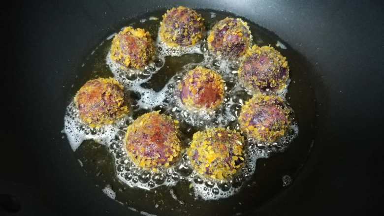 外酥里嫩还甜蜜蜜的紫薯蜜豆球,轻轻地翻动几次后，面包糠变成金黄色后即可出锅。
注意，注意，一定要经常翻动哦，不然会烧焦，变黑呢。