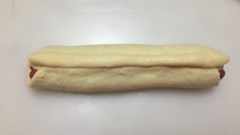 爱心💗吐司,将另一条15克的白色棒状面团放在接合处上方,用手指轻轻按压。