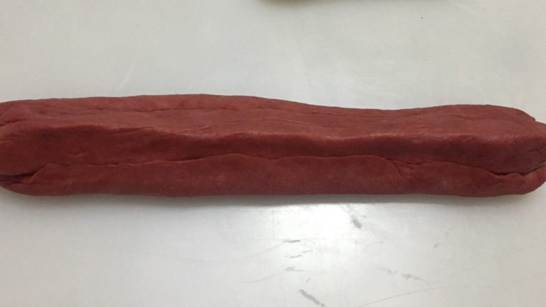 爱心💗吐司,把9翻面,用手指捏合粗的红色棒状面团和细的红色面团的结合处,再捏塑成爱心的形状。