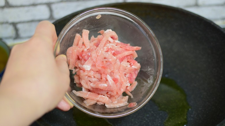 鱼香肉丝,锅中加油,大火将油烧至七成热(七成热就是表面有青烟大量上升时),加入腌制好的肉丝