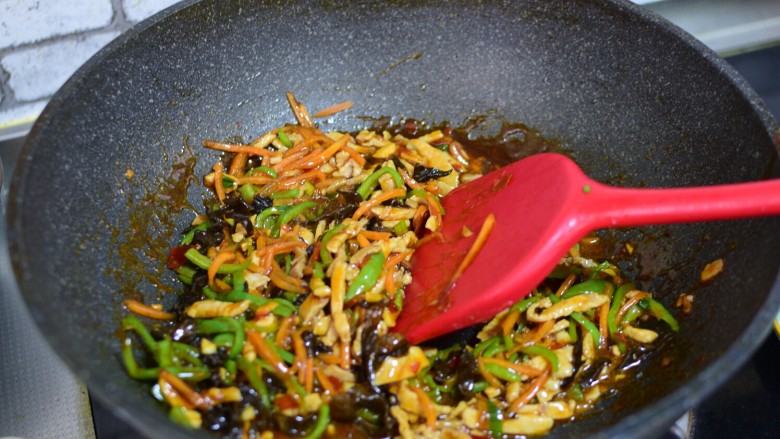 鱼香肉丝,加入尖椒、木耳、胡萝卜、熟肉丝,一起翻炒均匀