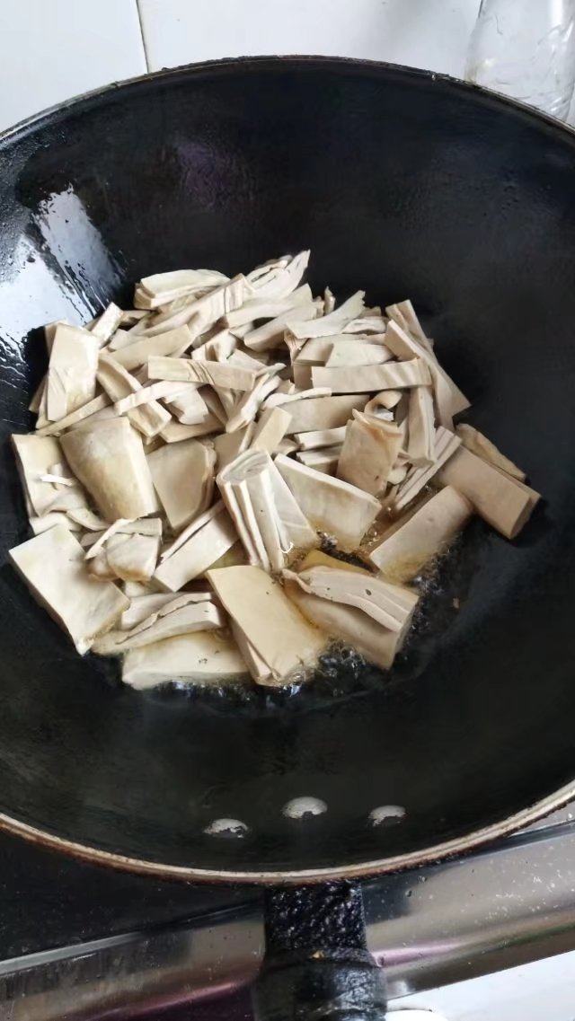 砂锅菠菜烧豆腐皮,锅里入油,加入豆腐皮用油煎