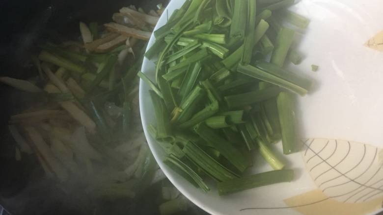 咸肉香干炒青蒜,倒入蒜叶,翻炒;