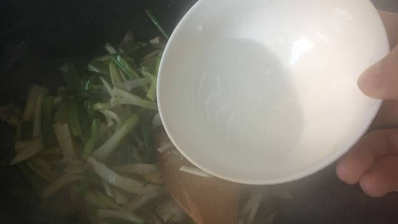 咸肉香干炒青蒜,可以加入一点水,继续翻炒;不需要盖锅盖,保持蒜叶的色泽;