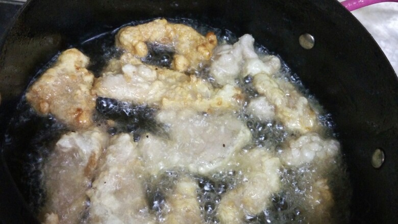 东北锅包肉
(茄汁锅包肉),锅里烧热油,将肉片炸至金黄色捞出