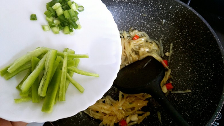 酸辣土豆丝,再倒入青椒丝跟葱花