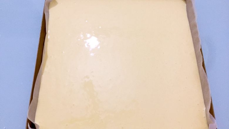 原味蛋糕卷,烤盘铺上油纸,把蛋糕糊倒进烤盘中,抹平表面,提起烤盘震一震,震出大气泡