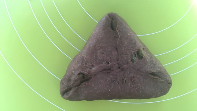 可可软欧,之后翻转个面,将光滑的一面朝下,对折起三面成三角形,将对折处捏紧