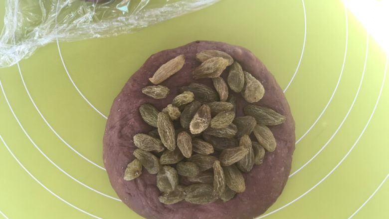 可可软欧,包裹上一半葡萄干,多次对折面团,将葡萄干跟面团揉均匀
