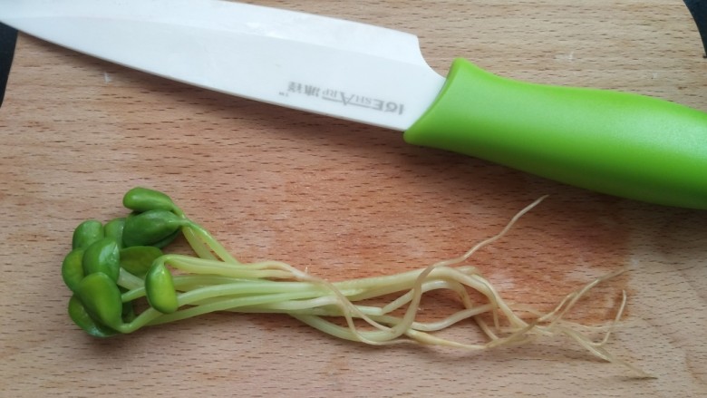 黑豆芽培根卷,黑豆芽六七根头冲一头,码起放在案板上。