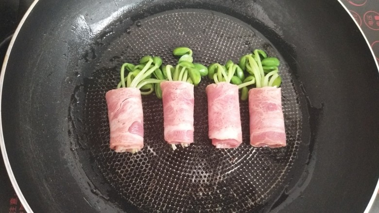 黑豆芽培根卷,放入培根卷,蛋液接头的那一面先紧挨锅底放。