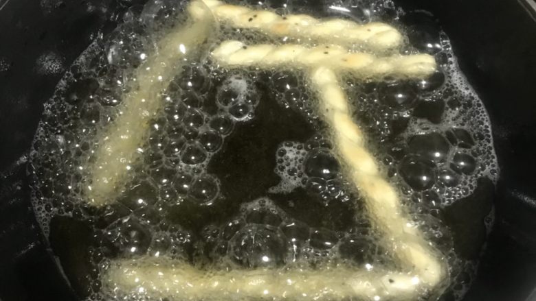 酥脆小麻花,玉米油倒入平底锅烧至六成热下麻花坯,自动浮出