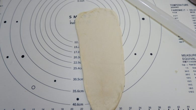 蔓越莓椰蓉面包卷,取一个面团,擀成牛舌状,稍微长一些,上端2厘米位置擀的薄一些,一会收口用。