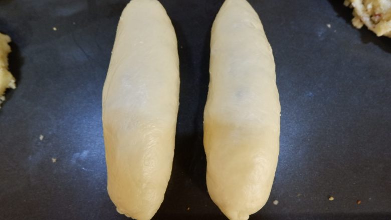 蔓越莓椰蓉面包卷,整形成橄榄状,收口向下放入烤盘进行二次发酵。