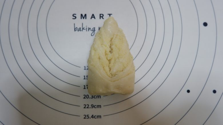叶子椰蓉面包,尖的一头穿过切口。翻面后稍整一下形即可。