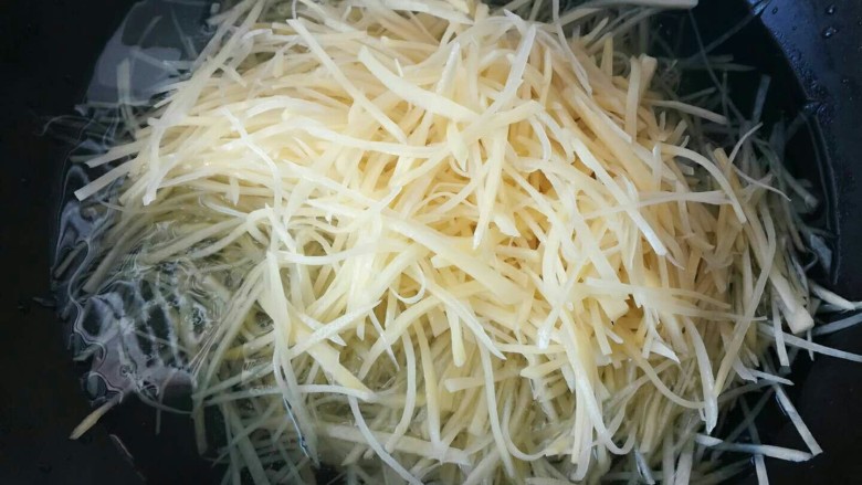 炝拌土豆丝,锅中加入水,水开后把土豆丝放入锅中焯一下。