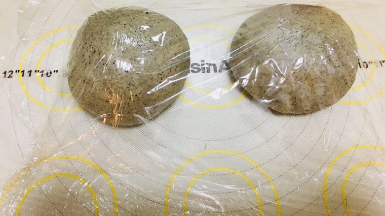 黑芝麻软欧,面团分割成2份,排气滚圆。覆盖保鲜膜松弛30分钟。