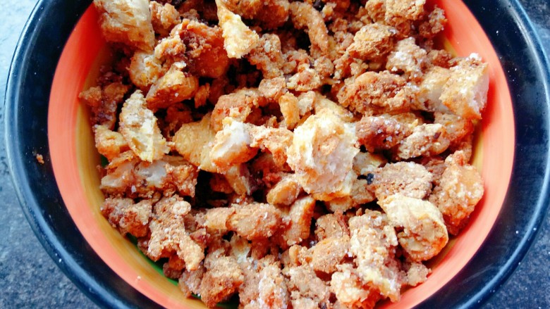 油梭子饼,准备好油渣，用擀面杖捣碎，再放入少许的食盐拌匀。