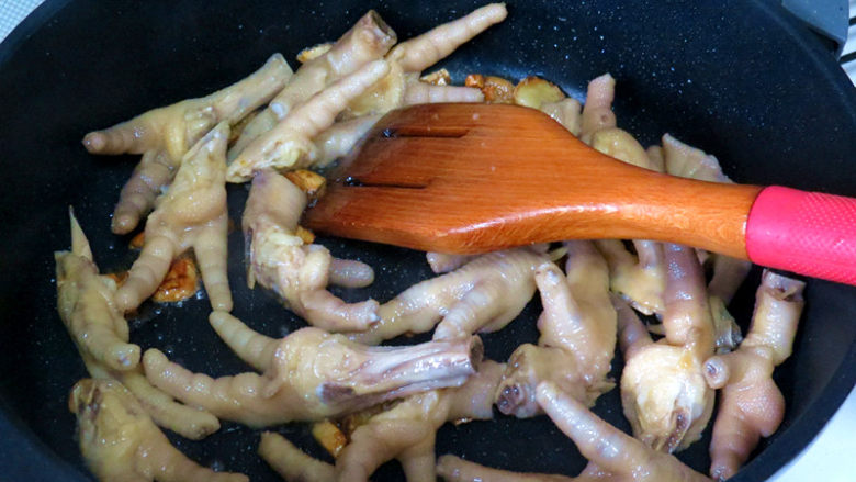 佐餐下酒菜【香卤鸡爪】,倒入鸡脚翻炒上色