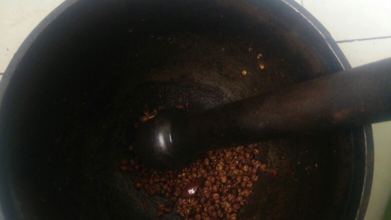 水煮肉片,将花椒倒入捣窝中，用倒锤砸细。