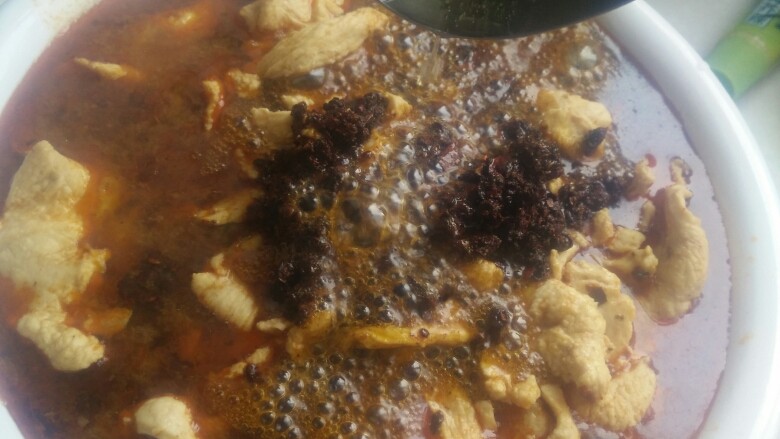 水煮肉片,将热油浇在花椒、辣椒碎上