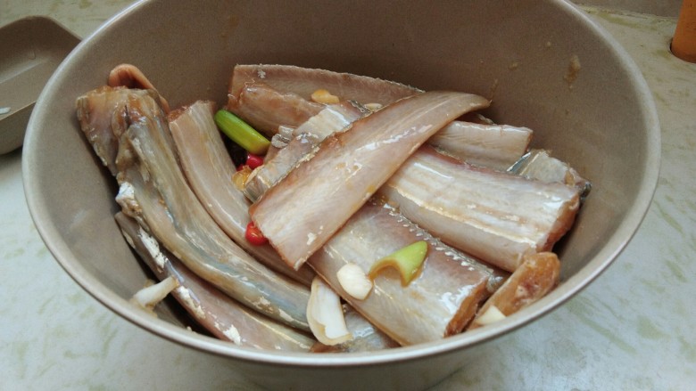 酒香煎带鱼,用筷子拌匀,每段带鱼上都涂上调味料