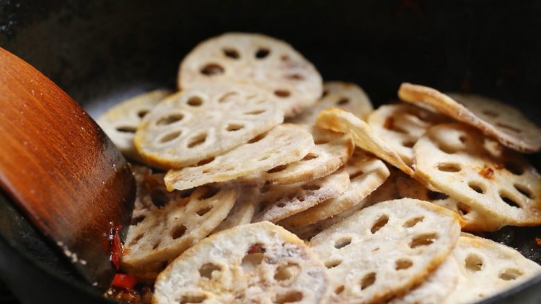 川味回锅藕片,放入炸好的藕片,用大火翻炒2分钟,使藕片均匀裹上酱汁。
