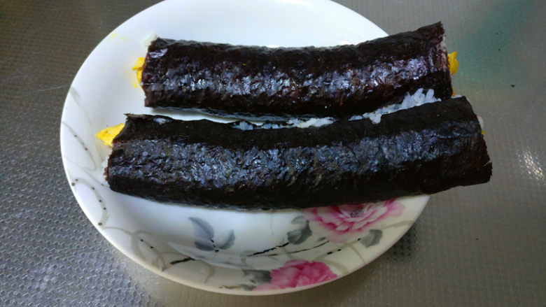 简单易学的寿司,用寿司帘将海苔卷起,压实备用。