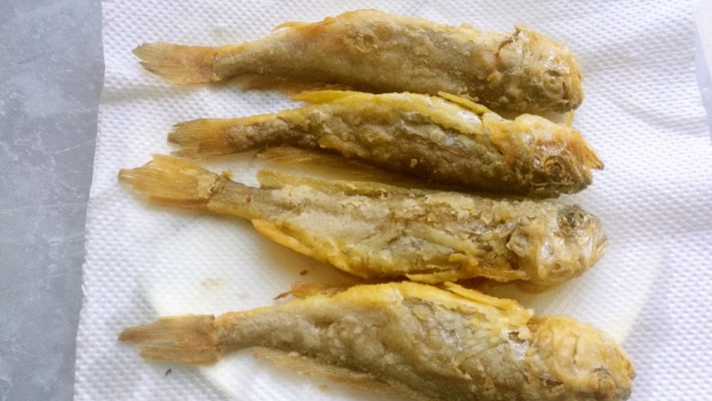 干炸黄花鱼,炸至金黄酥脆捞出来,放在厨房纸上控油。