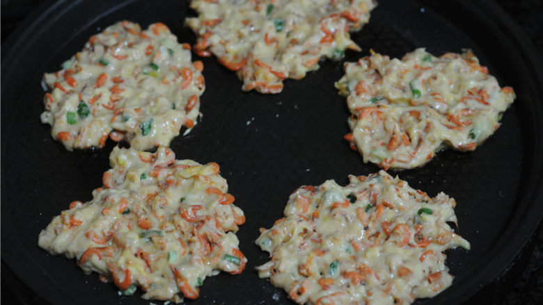 虾饼,用勺子舀一勺糊糊放进电饼铛里,用筷子将面糊弄平成饼状