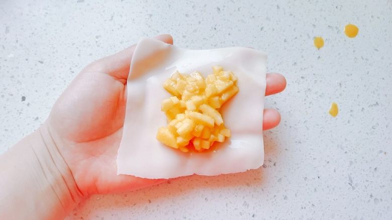 油煎苹果饺子,用勺子捞些苹果丁到饺子皮中间,尽量过滤掉蛋液。然后四周捏起来,我用的最简单的造型,可以捏褶等,自己发挥。